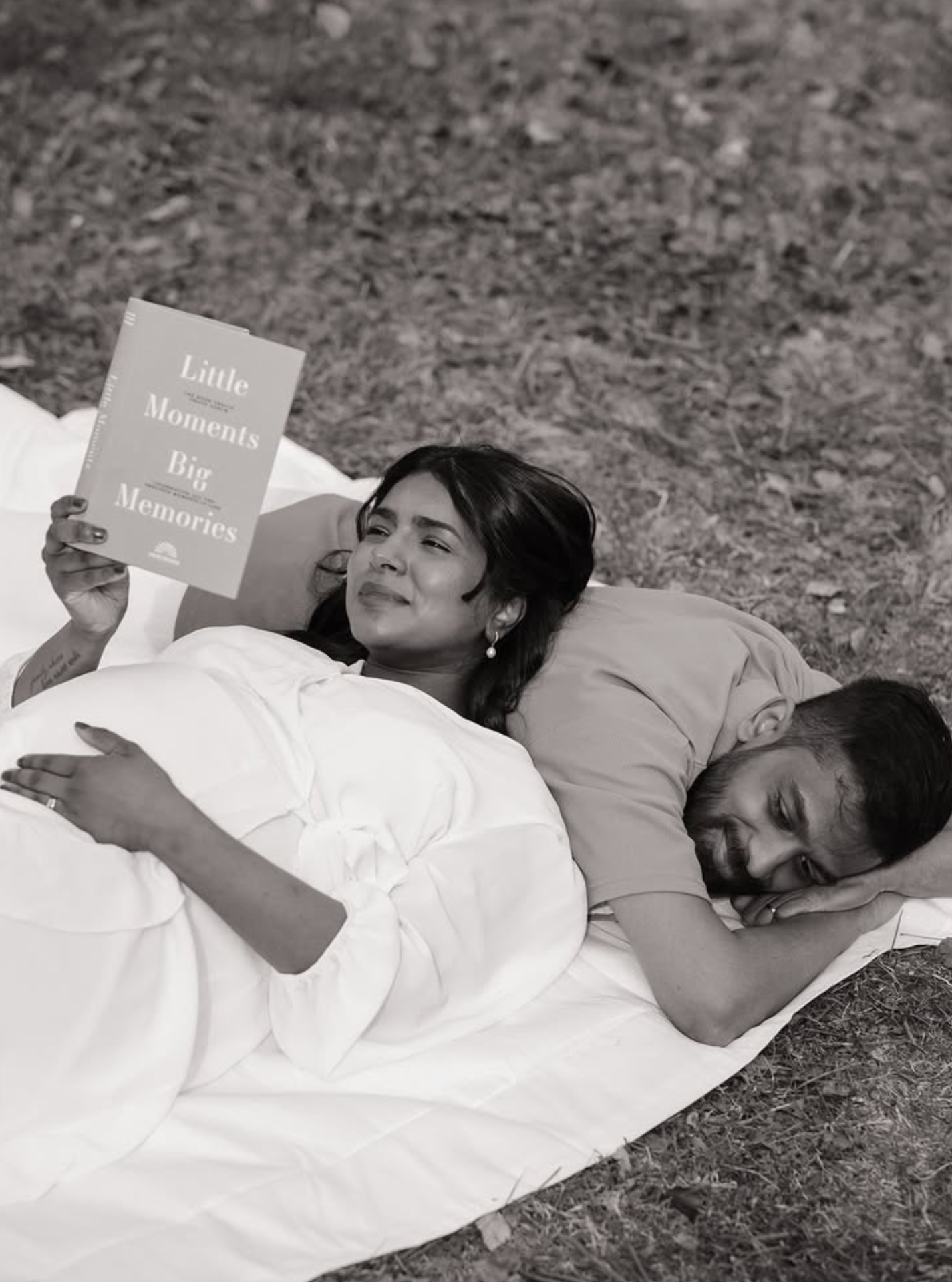 Expecting couple resting on a blanket in soft light photographed by Pamila